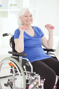 Image of older woman in wheelchair, using hand weights
